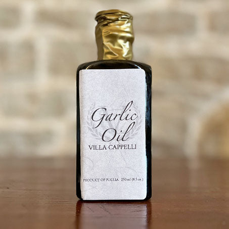 A bottle of Villa Cappelli Garlic Oil sitting on a table.