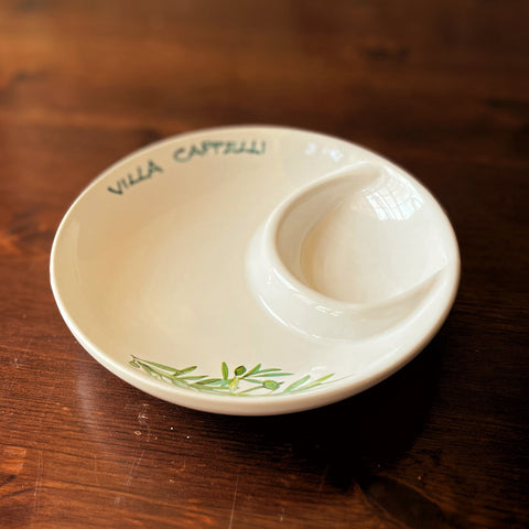 The Spuntino Server by Villa Cappelli showcases a curved divider and green leaf motif, adding Mediterranean charm to your table, especially when displayed on wood.