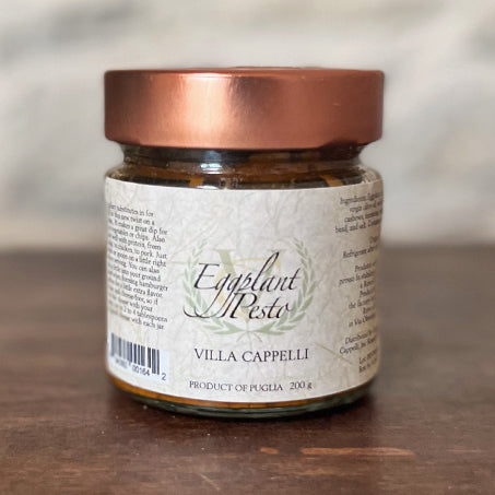 A jar of Pesto Collection by Villa Cappelli on a wooden table.