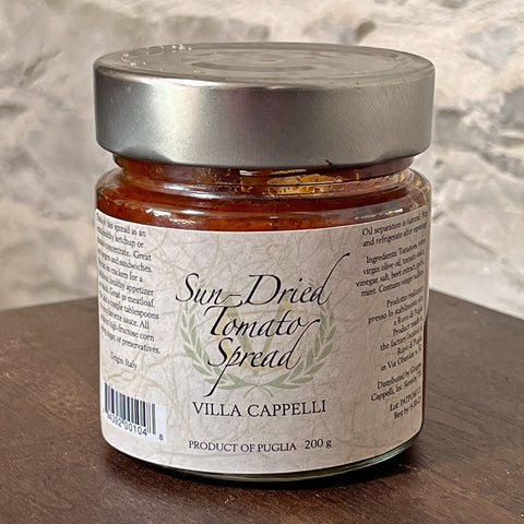 A jar of Villa Cappelli Sun-Dried Tomato Spread sitting on a table.
